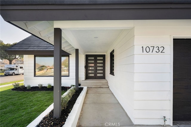 property entrance featuring a lawn