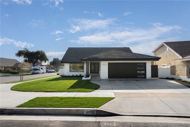 view of front of house featuring a garage and a front lawn