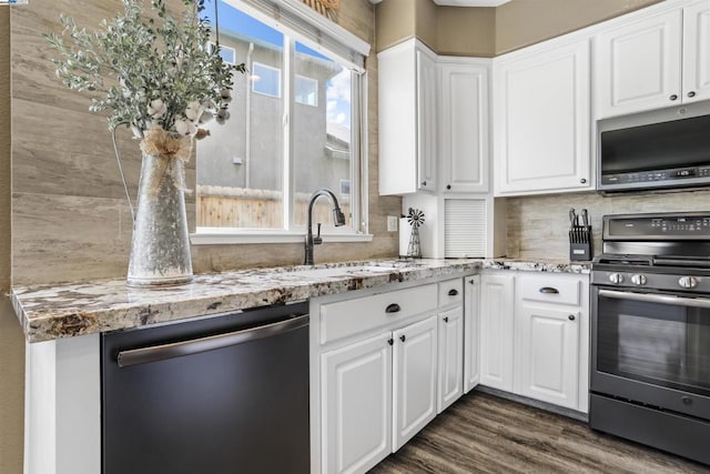 kitchen featuring sink, white cabinetry, light stone countertops, and appliances with stainless steel finishes