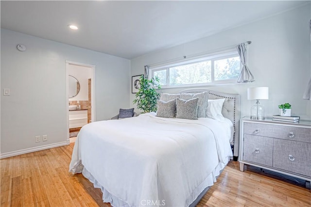 bedroom featuring ensuite bath and light wood-type flooring