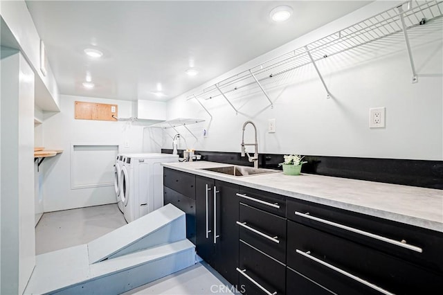 laundry area with sink, separate washer and dryer, and cabinets