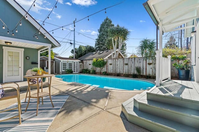 view of pool with a patio and an outbuilding