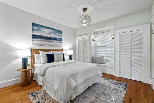 bedroom with multiple closets and hardwood / wood-style floors