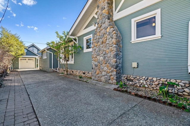 view of side of home with a garage and an outbuilding