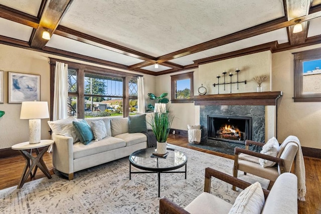 living room featuring coffered ceiling, a high end fireplace, hardwood / wood-style flooring, and beamed ceiling