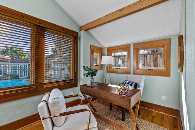 office with hardwood / wood-style floors, lofted ceiling with beams, and plenty of natural light