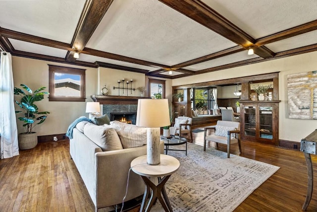 living room featuring beam ceiling, coffered ceiling, hardwood / wood-style floors, and a fireplace