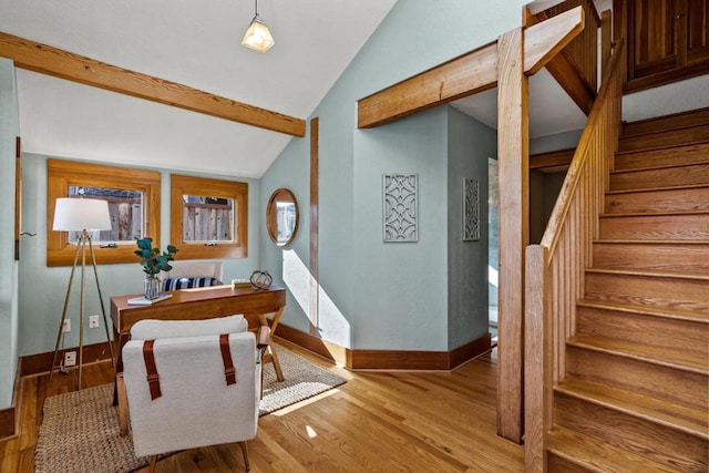 entryway with light hardwood / wood-style floors and vaulted ceiling with beams