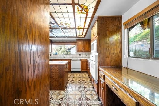 kitchen with white appliances, a wealth of natural light, and tasteful backsplash