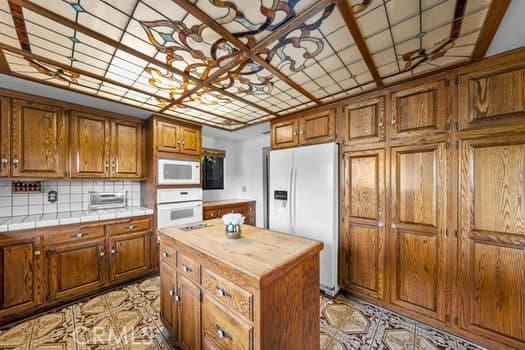 kitchen with white appliances, a center island, and tasteful backsplash