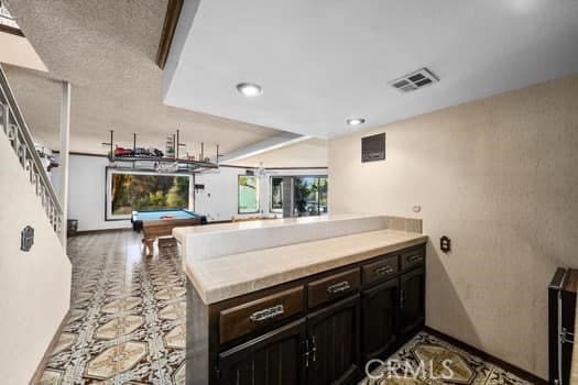 kitchen featuring kitchen peninsula, dark brown cabinets, and billiards