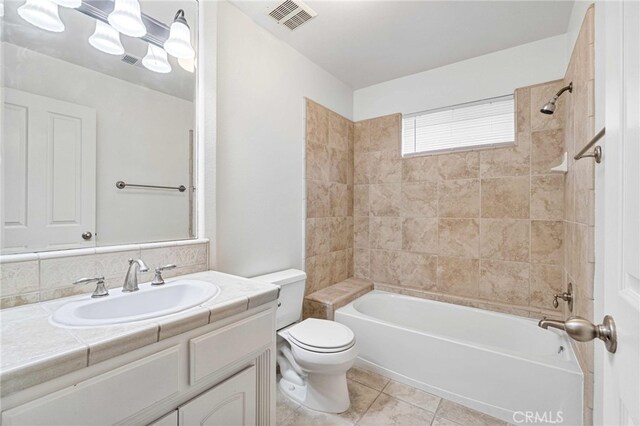 full bathroom with tile patterned floors, toilet, tiled shower / bath, and vanity