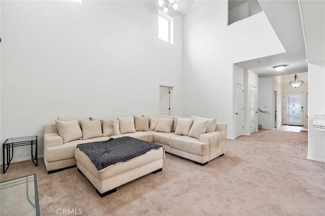 carpeted living room featuring a towering ceiling