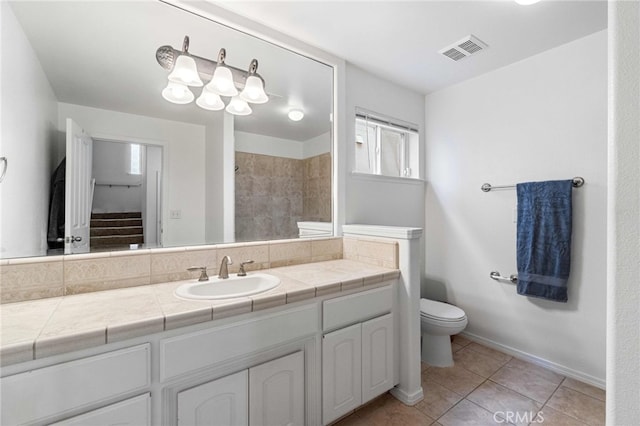 bathroom with toilet, tile patterned floors, and vanity