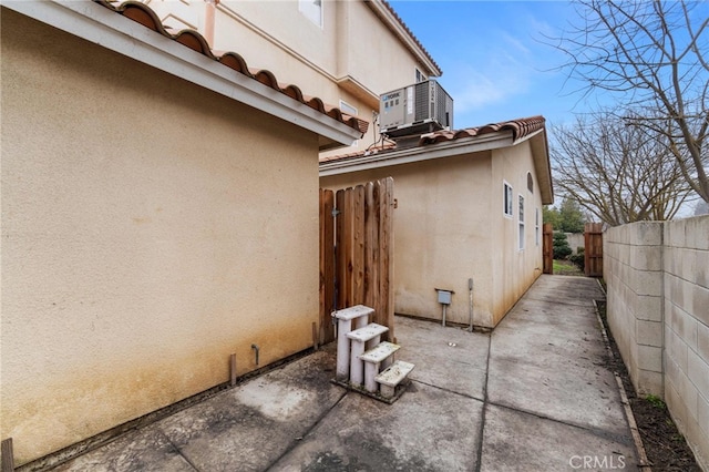 view of home's exterior with cooling unit and a patio