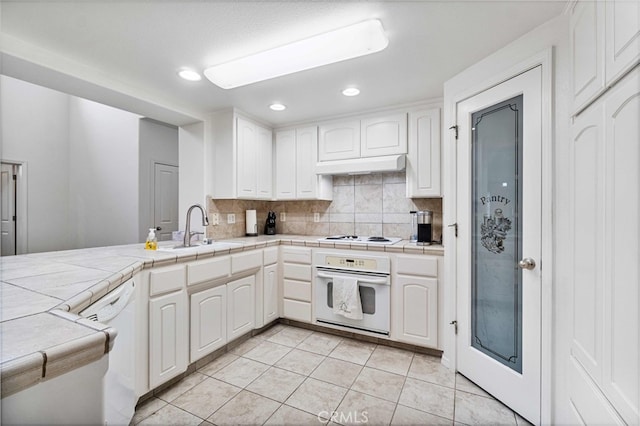 kitchen with white cabinetry, white appliances, and tile counters