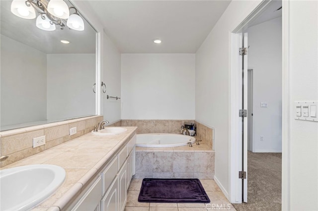 bathroom with tiled tub, tile patterned floors, and vanity