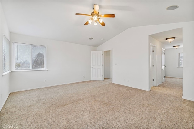 carpeted empty room with lofted ceiling, ceiling fan, and a wealth of natural light