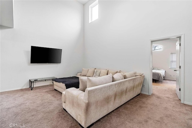 living room featuring a towering ceiling and carpet flooring