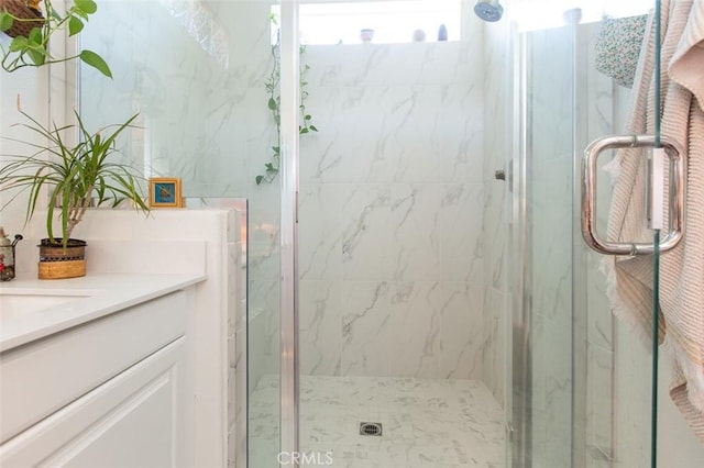 bathroom featuring an enclosed shower, a healthy amount of sunlight, and vanity