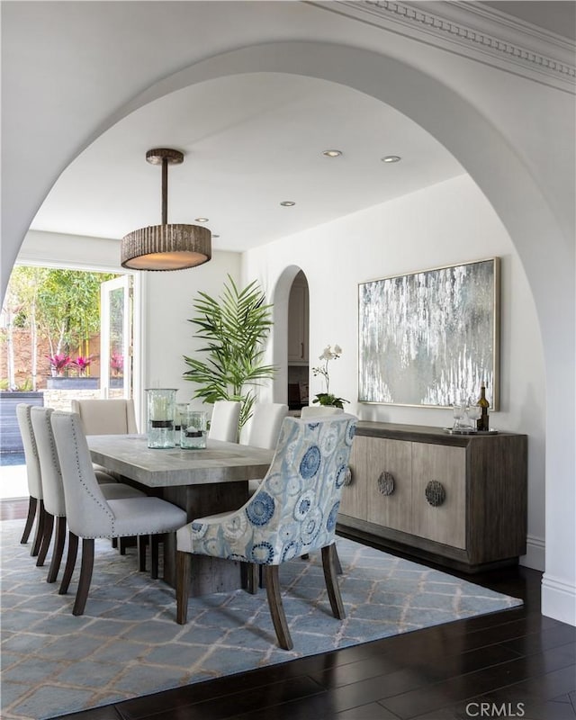 dining space featuring dark wood-type flooring and ornamental molding