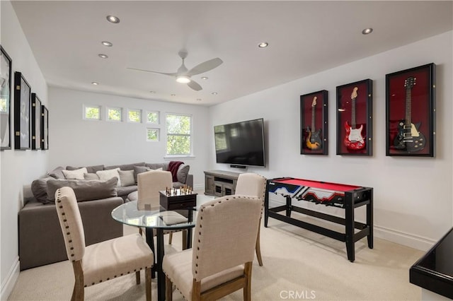 dining space featuring light carpet and ceiling fan