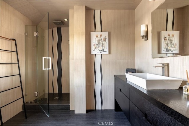 bathroom featuring tile walls, a shower with door, tile patterned floors, and vanity