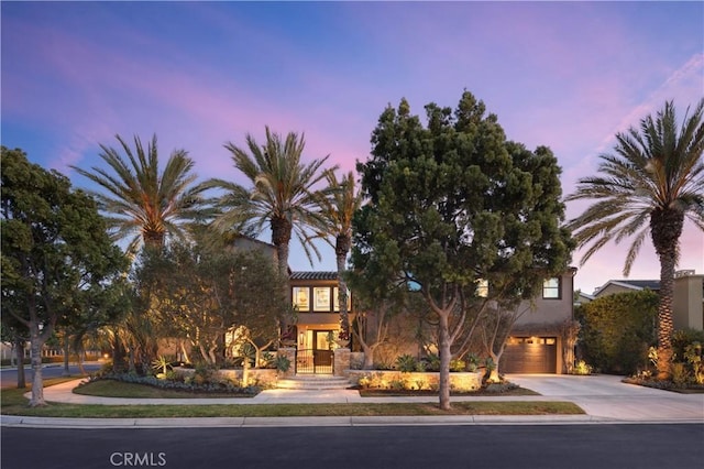 view of property hidden behind natural elements featuring a garage