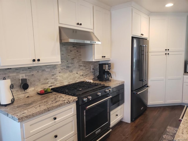 kitchen with light stone counters, backsplash, white cabinets, and high quality appliances