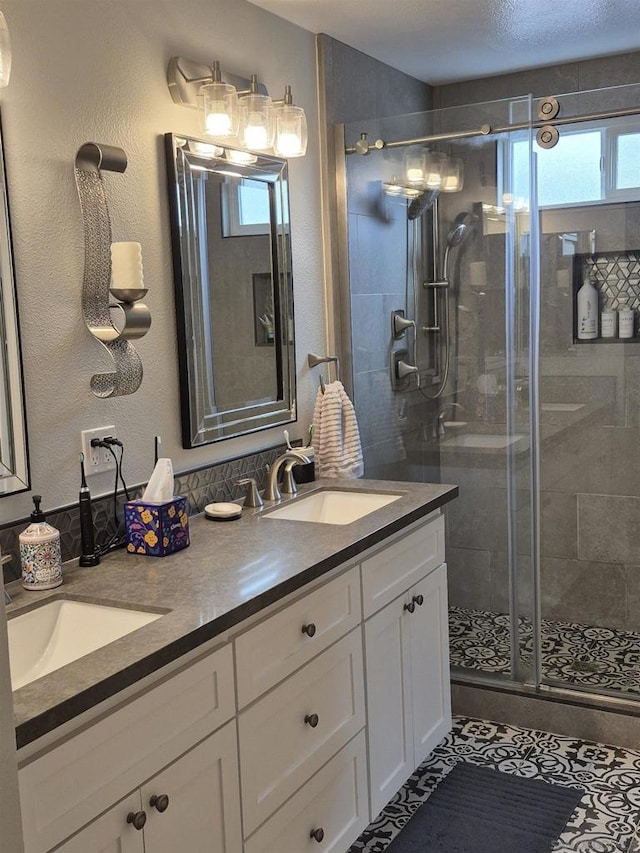 bathroom featuring a shower with shower door, vanity, tile patterned floors, and a wealth of natural light