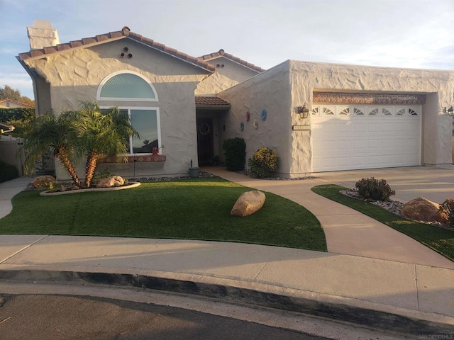 mediterranean / spanish-style home featuring a front yard and a garage