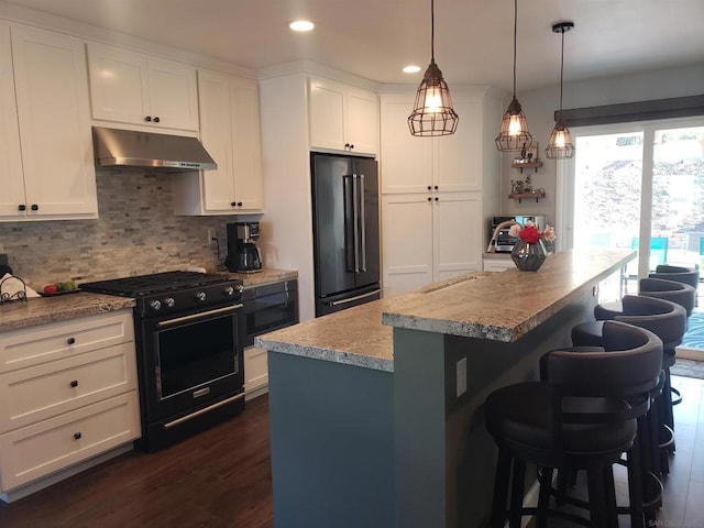 kitchen featuring a center island, decorative light fixtures, white cabinetry, high end appliances, and a breakfast bar area