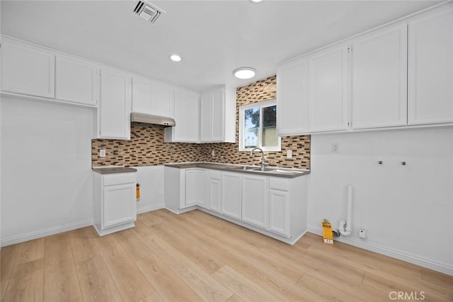 kitchen with white cabinets, light wood-type flooring, and sink