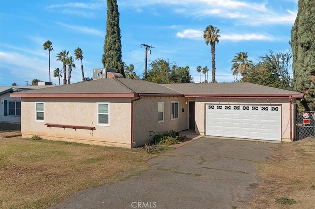 single story home with a garage and a front lawn