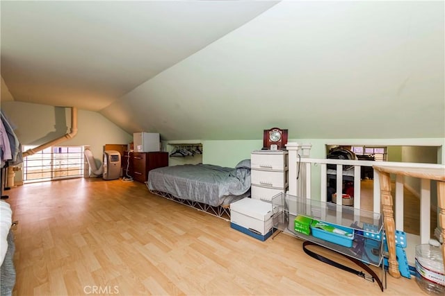 bedroom featuring lofted ceiling and light wood-type flooring