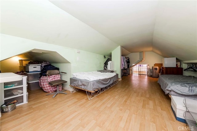 bedroom featuring lofted ceiling and light hardwood / wood-style flooring