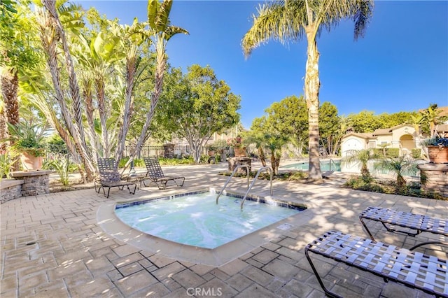 view of swimming pool with a community hot tub and a patio