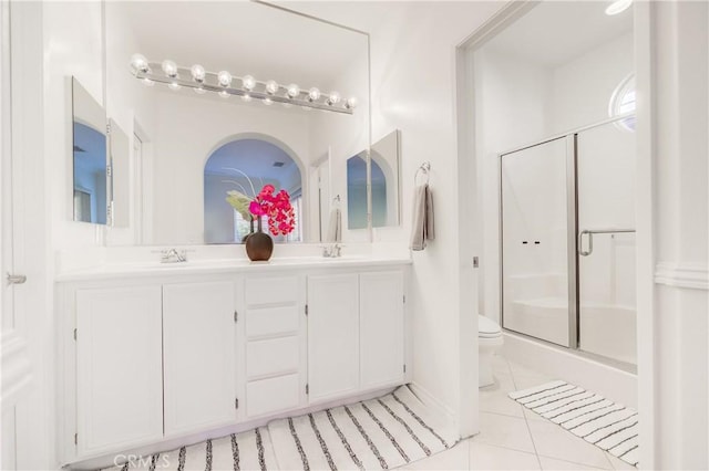 bathroom with toilet, tile patterned flooring, walk in shower, and vanity