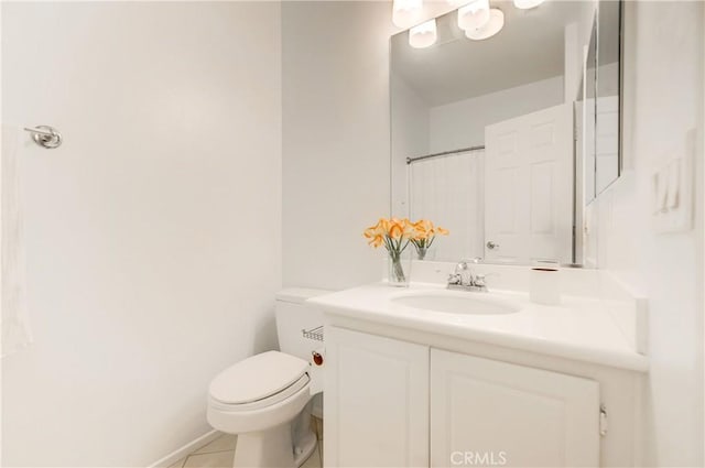 bathroom with toilet, vanity, and tile patterned flooring