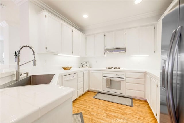 kitchen with white cabinetry, sink, white appliances, and light wood-type flooring