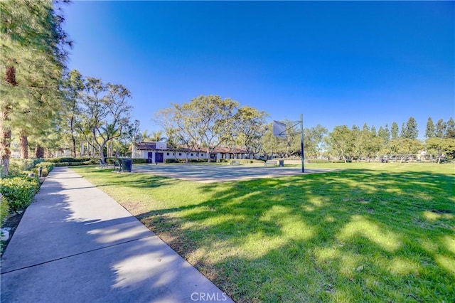 surrounding community with a yard and basketball hoop