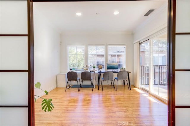 interior space with light hardwood / wood-style flooring, ornamental molding, and a healthy amount of sunlight