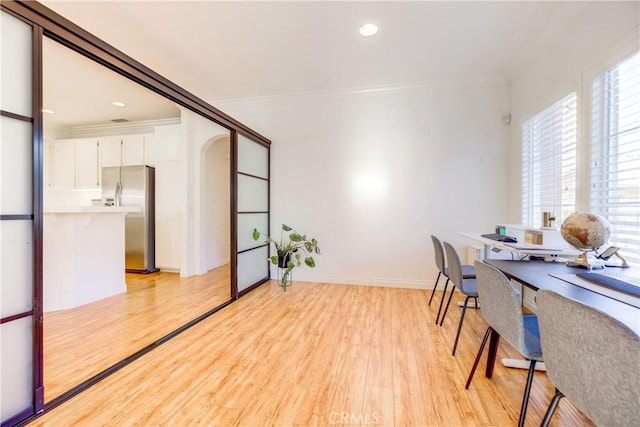 office with light hardwood / wood-style flooring and ornamental molding