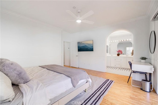 bedroom with light wood-type flooring, ceiling fan, ensuite bathroom, and crown molding