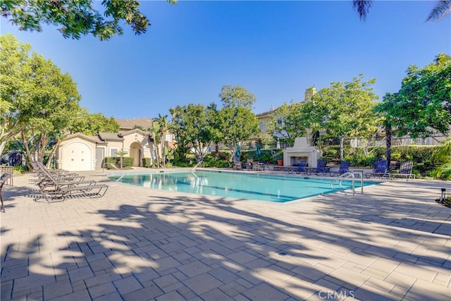 view of pool featuring an outdoor fireplace and a patio area