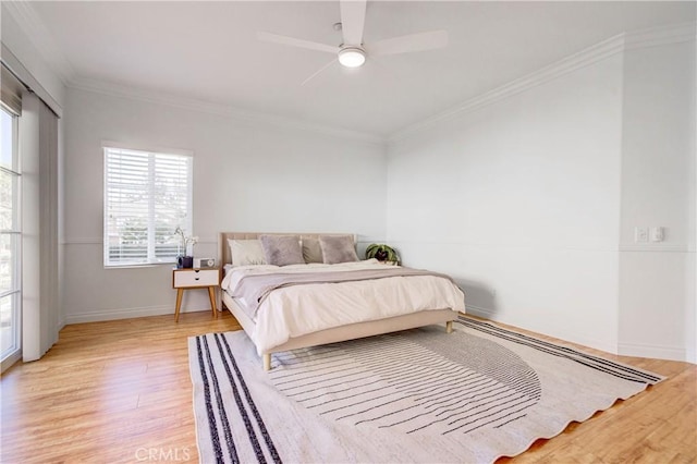 bedroom featuring ceiling fan, crown molding, and light hardwood / wood-style flooring