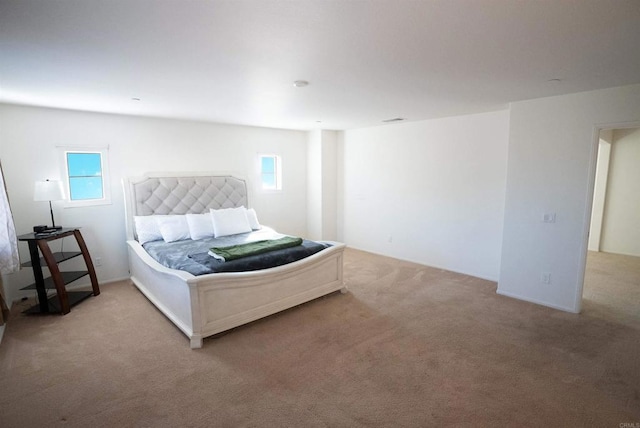 bedroom featuring multiple windows and light carpet