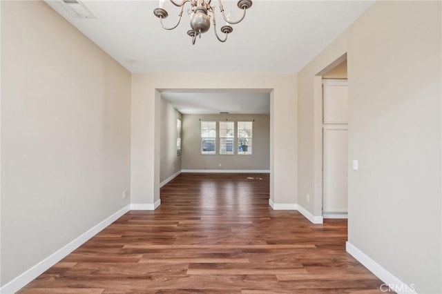 interior space with dark wood-type flooring and an inviting chandelier