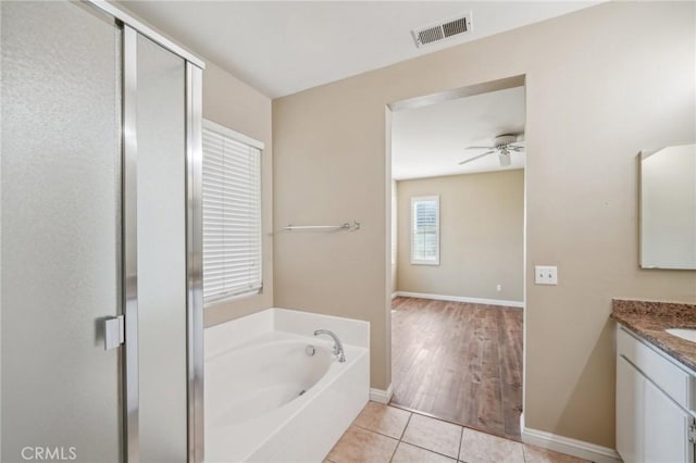 bathroom featuring tile patterned flooring, plus walk in shower, ceiling fan, and vanity