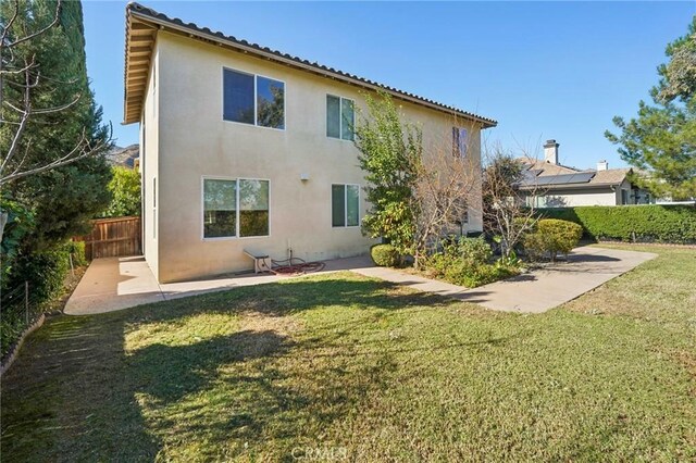 rear view of property with a lawn and a patio area